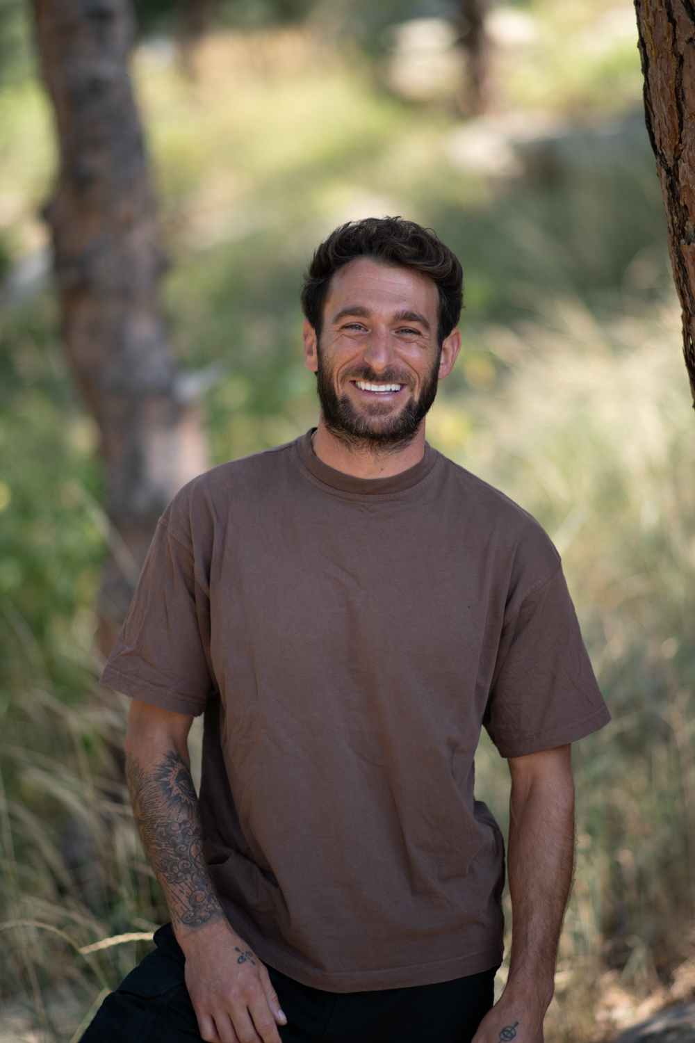 Nicholas Balsamo smiling in warm sunlight among tall grass